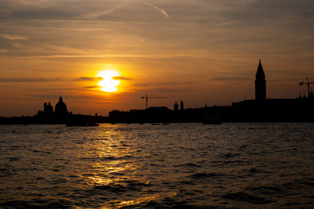 Venice city skyline silhouette at sunset from the Venetian Lagoon in Italy.