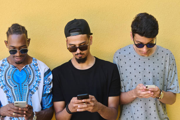 istock Diverse Teen Group Standing Together Against Wall Using Smartphones 2156963610