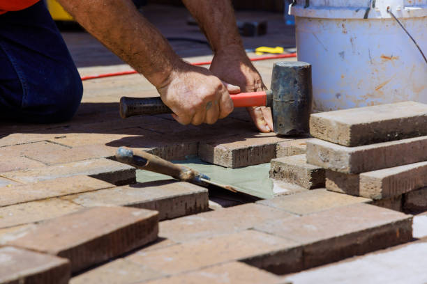 istock In course of reconstructing a footpath, an employee is engaged in repairing damaged bricks 2156964880