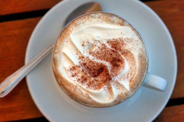 istock cappuccino with cream top view, on a wooden table 2156968846
