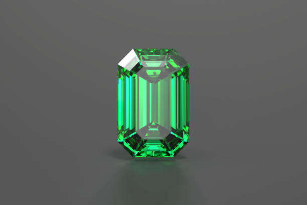 Sparkling emerald gemstone held in tweezers