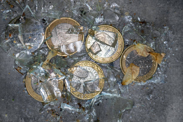 Glass jar with euro coins has fallen on a tiled  dirty floor. Perhaps a symbol for the turbulent times of the European Union