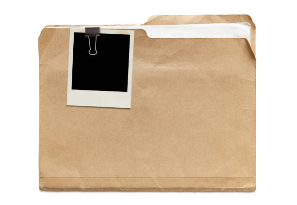 Old Manila Folder Old run-down manila folder with papers and attached instant photo isolated on white background manila folder and paper clip stock pictures, royalty-free photos & images