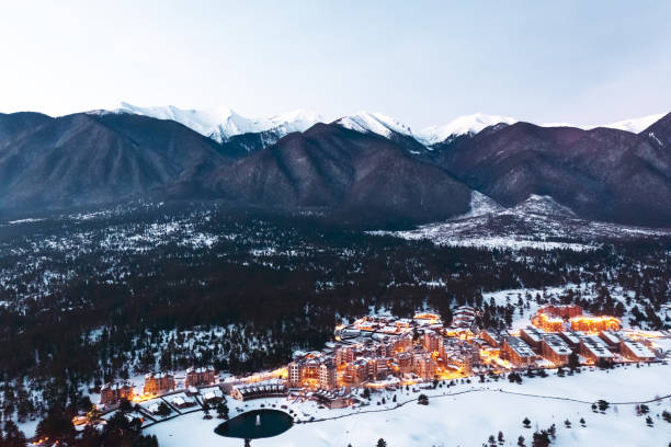 istock Aerial view Pirin Golf Club ski resort. Resort complex with golf course is illuminated with orange light at foot of mountain against backdrop of sunset day winter. Drone. Travel concept. Tourism 2156978040