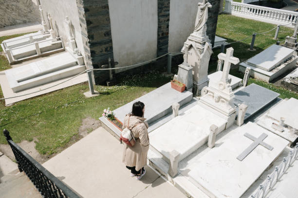 An ancient stone crypt surrounded by weathered tombstones and graves in a serene cemetery, a somber and timeless burial place.