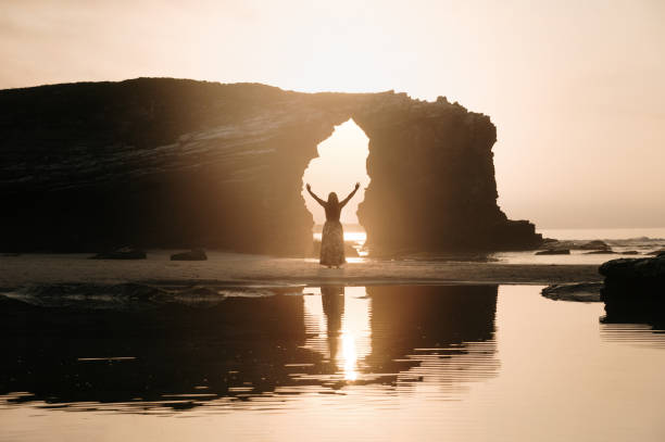 Young woman with arms raised on a beach