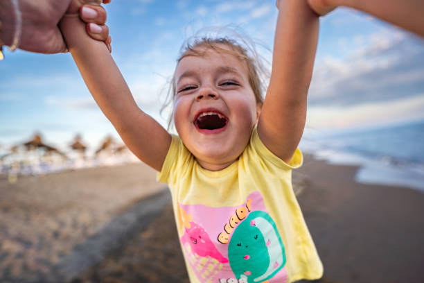 istock Little girl spinning on the beach 2156981142