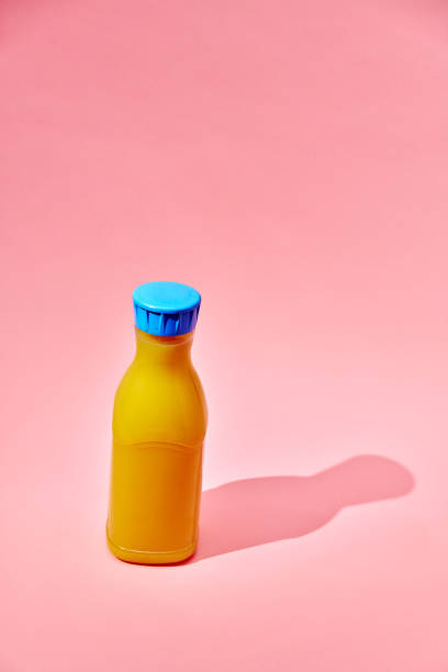 istock Orange Juice in Recycled PET Plastic Bottle on Pink Background 2156982573