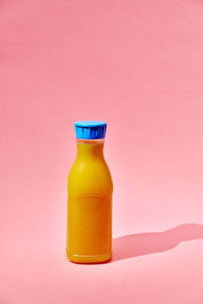 istock Orange Juice in Recycled PET Plastic Bottle on Pink Background 2156982575
