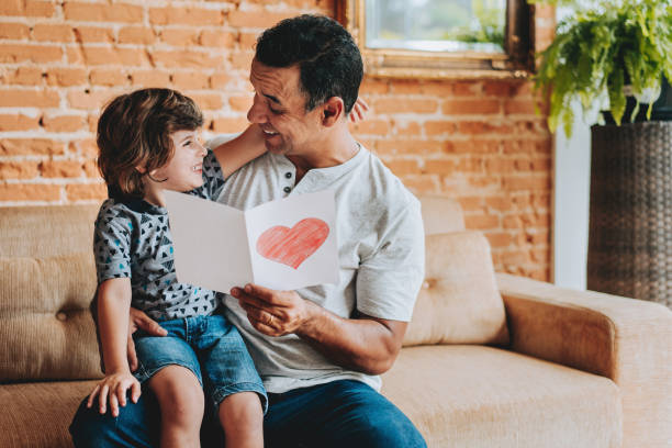 istock Son handing postcard to father on father's day 2156983778