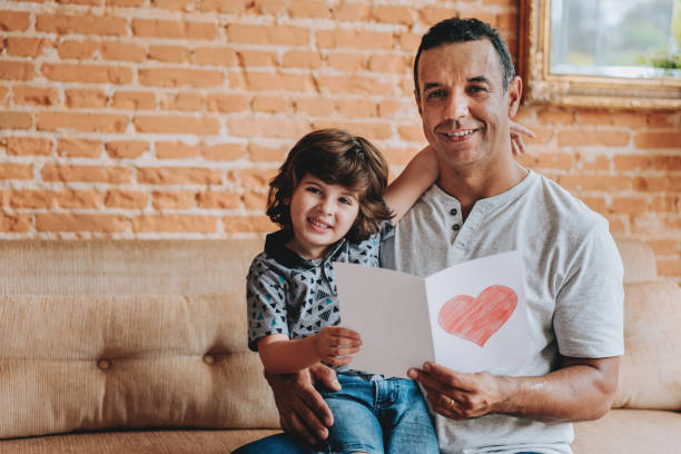 istock Son handing postcard to father on father's day 2156983780