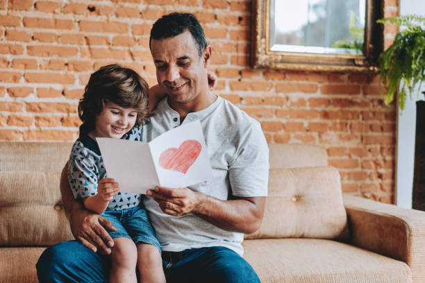 istock Son handing postcard to father on father's day 2156983793