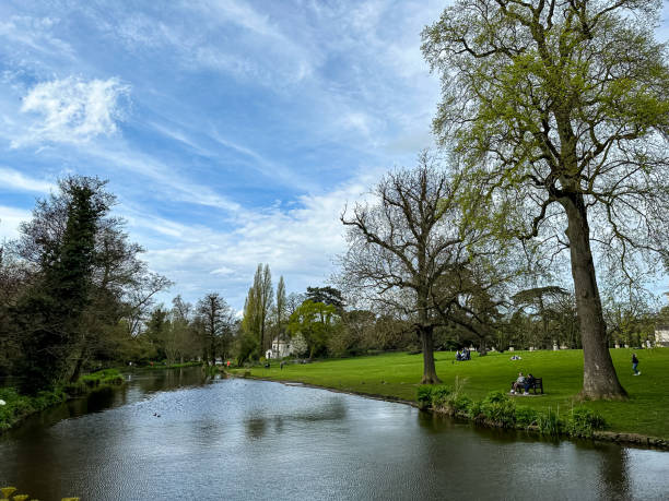 People visible alongside the River Wye at Ashford in the Water in Peak District National Park at Derbyshire, England