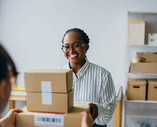 istock Smiling Woman Receiving Package in Office Setting 2156987569
