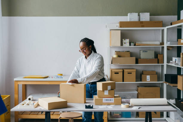 istock Young Woman Working in a Modern Office Packing Boxes 2156987604