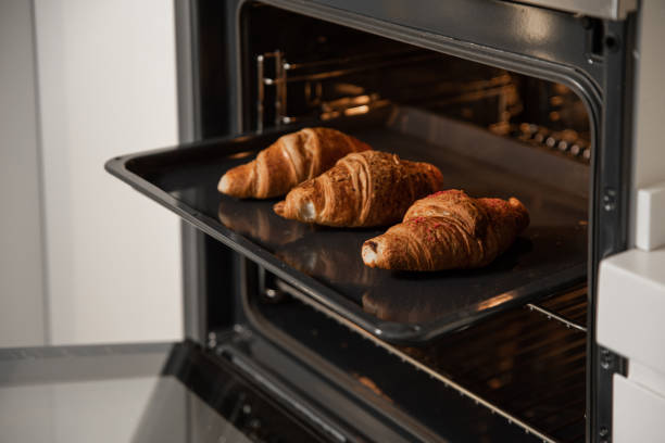 istock Croissants on a baking tray in built in oven in the kitchen 2156987761