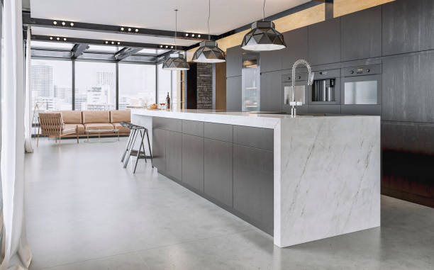 Side view of a modern high black kitchen with long rectangular white marble breakfast kitchen island, stools, roof beams, living room with sofa and windows in the background A side view of a high black modern kitchen with an empty long rectangular white marble breakfast kitchen island (only with a wine bottle and glasses, bowl of nuts) with stools in front, on the gray cement tiled floor. Three black elegant design pendant lights, kitchen utensils, a silver faucet, in front of a hardwood paneled wall and white plaster wall... black cabinets with a built-in coffee maker and two ovens, and a high wine fridge. A gray sofa with pillows, a low coffee table in fornt of large panoramic windows on a side with a nice city view in the background. Ceiling with black steel construction, beams, pillars and hardwood elements. 3D rendered image. streaky lights stock pictures, royalty-free photos & images