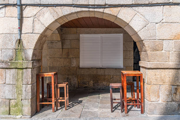 High wooden tables and chairs, on the terrace of a bar