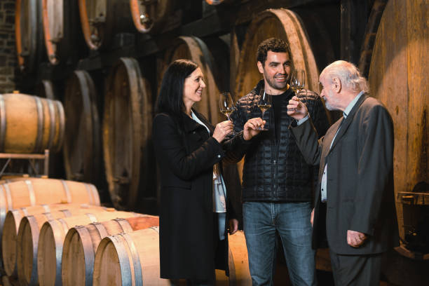 istock Wine cellar guests, a woman and two men tasting a white wine 2156998568
