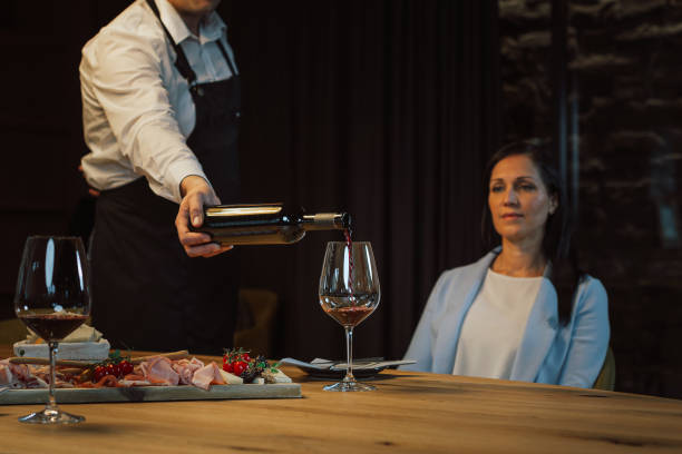 istock People drinking wine and eating in wine cellar 2156999322