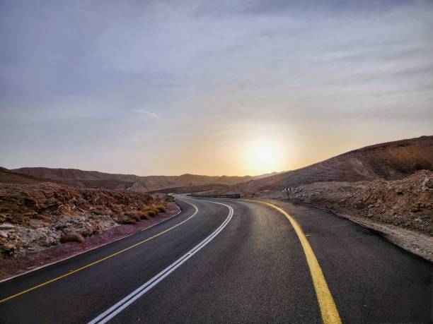 istock Road in the desert at sunset 2157000072