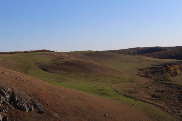 istock A grassy field with hills in the background 2157004728