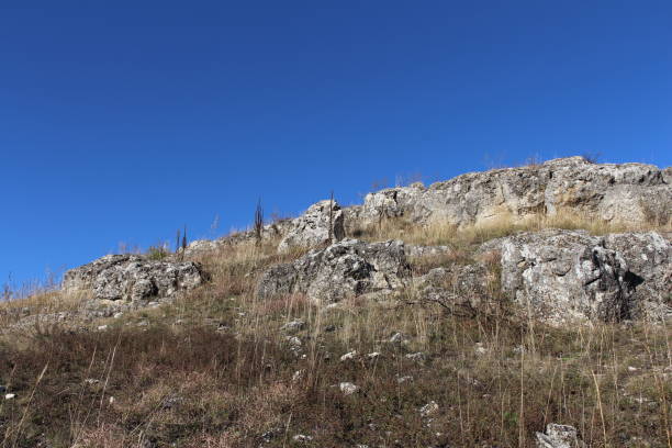 istock A grassy hill with a hill in the background 2157004871