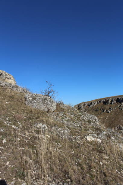 istock A grassy hill with a hill and blue sky 2157004890