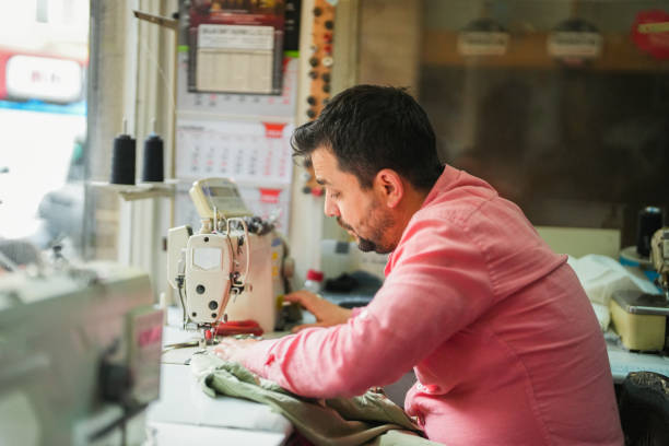 istock man tailor sewing in a small tailor shop. 2157005175