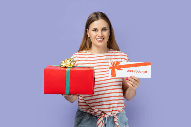 istock Woman holding gift voucher and red gift box, preparing present for giveaway. 2157015232