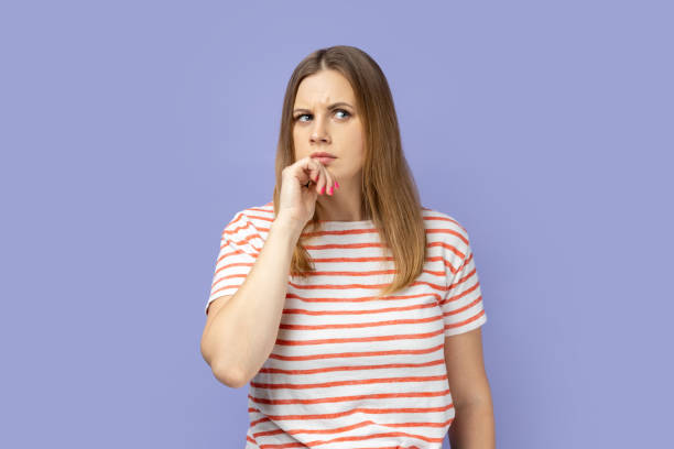 istock Woman standing deep in thoughts with puzzled serious doubtful face expression. 2157015237