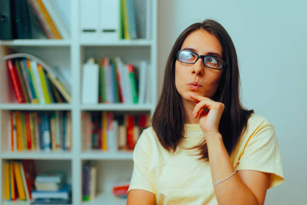 istock Woman Next to a Bookshelf Wondering What to Read 2157015562