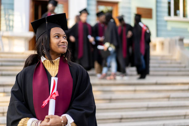 istock After finishing her degree, a graduate poses with her diploma 2157015622