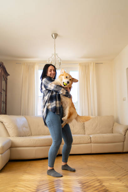 istock Young confident woman dancing with dog at home 2157015781