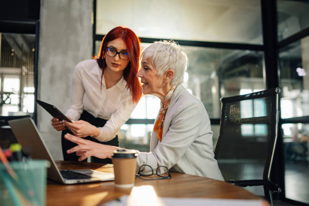 istock Old female executive discussing paperwork with her worker at office. 2157016211