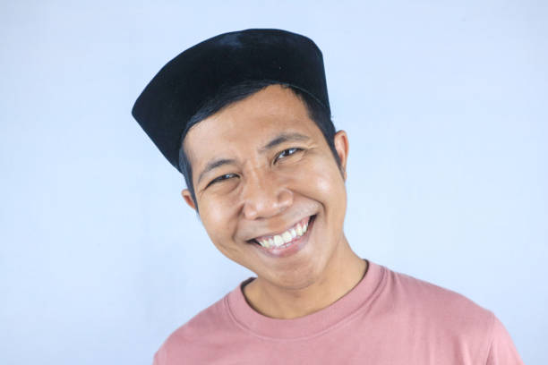 Smiling facial expression young asian man wearing hat happy looking at camera, isolated on white