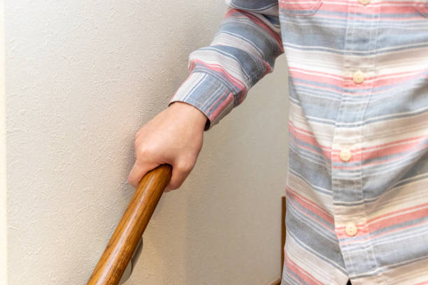 istock A man holding a handrail and descending the stairs 2157017459