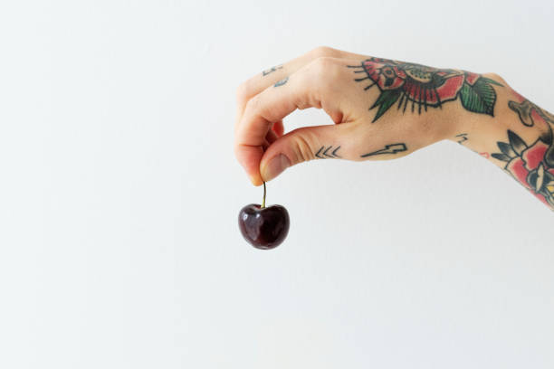 istock Tattooed hand holding a fresh cherry 2157021460