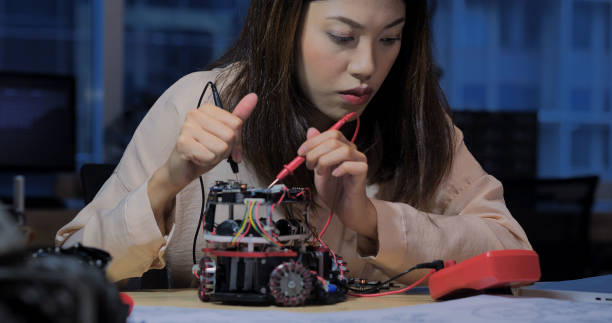 istock Woman Assembling a Small Robot at Desk. 2157022669
