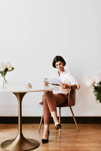 istock Cheerful woman reading a newspaper 2157024437