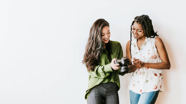 istock Happy women with a digital camera talking social template 2157024466