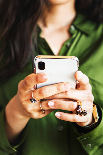 istock Woman in silk green shirt using a smartphone 2157024485