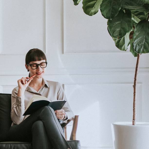 istock Casual young woman sitting on a couch with her planner 2157026757