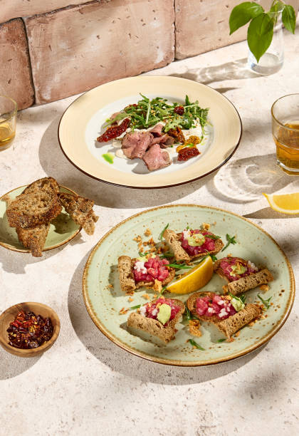 Authentic Sunlit Table Setting with Roast Beef and Tuna Tartare - Natural Still Life with Rustic Aesthetic.