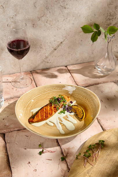 istock Sunlit Salmon Steak with Creamy Sauce on Rustic Beige Table Setting 2157026884
