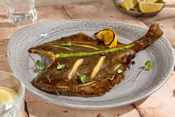 Authentic Sunlit Grilled Flounder with Lemon Wedge on Natural Beige Table