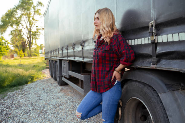 istock Woman truck driver leaned on her trailer, pensive, thinking 2157027601