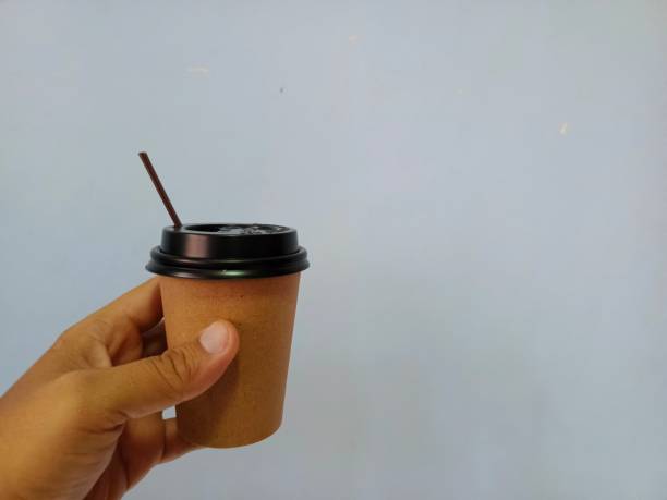 istock Hand holding a coffee cup with a gray background 2157029863