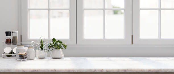 istock A white marble kitchen countertop features a coffee cup, decorative plants, and a seasoning shelf. 2157029917