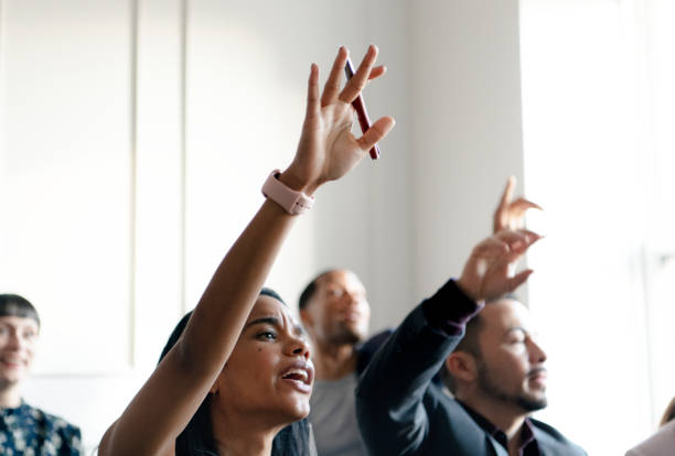 istock Business people in a seminar raising their hands 2157031267